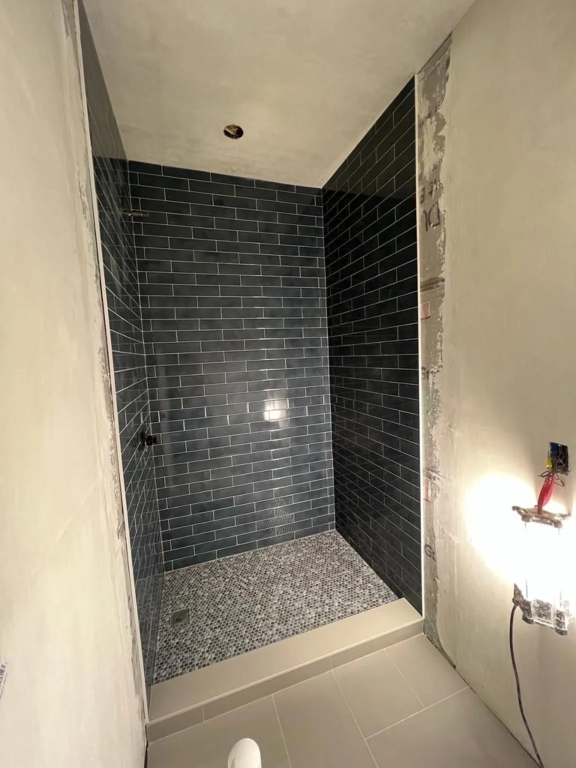 Blue shower tile installation in progress